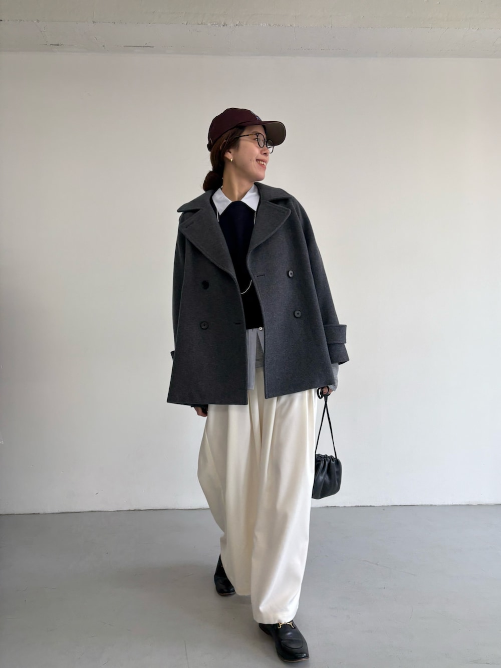 グレー系のピーコート、ホワイト系のその他パンツ、シルバー系のショルダーバッグを着用したレディースの冬コーディネートの6枚目の写真