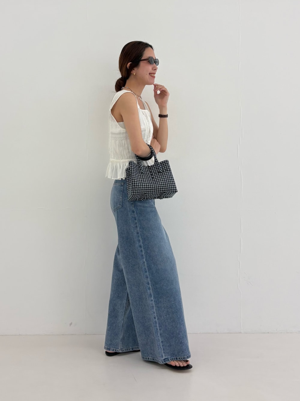 ブルー系のデニムパンツ、その他のトートバッグ、ホワイト系のシャツ/ブラウスを着用したレディースの夏コーディネートの8枚目の写真