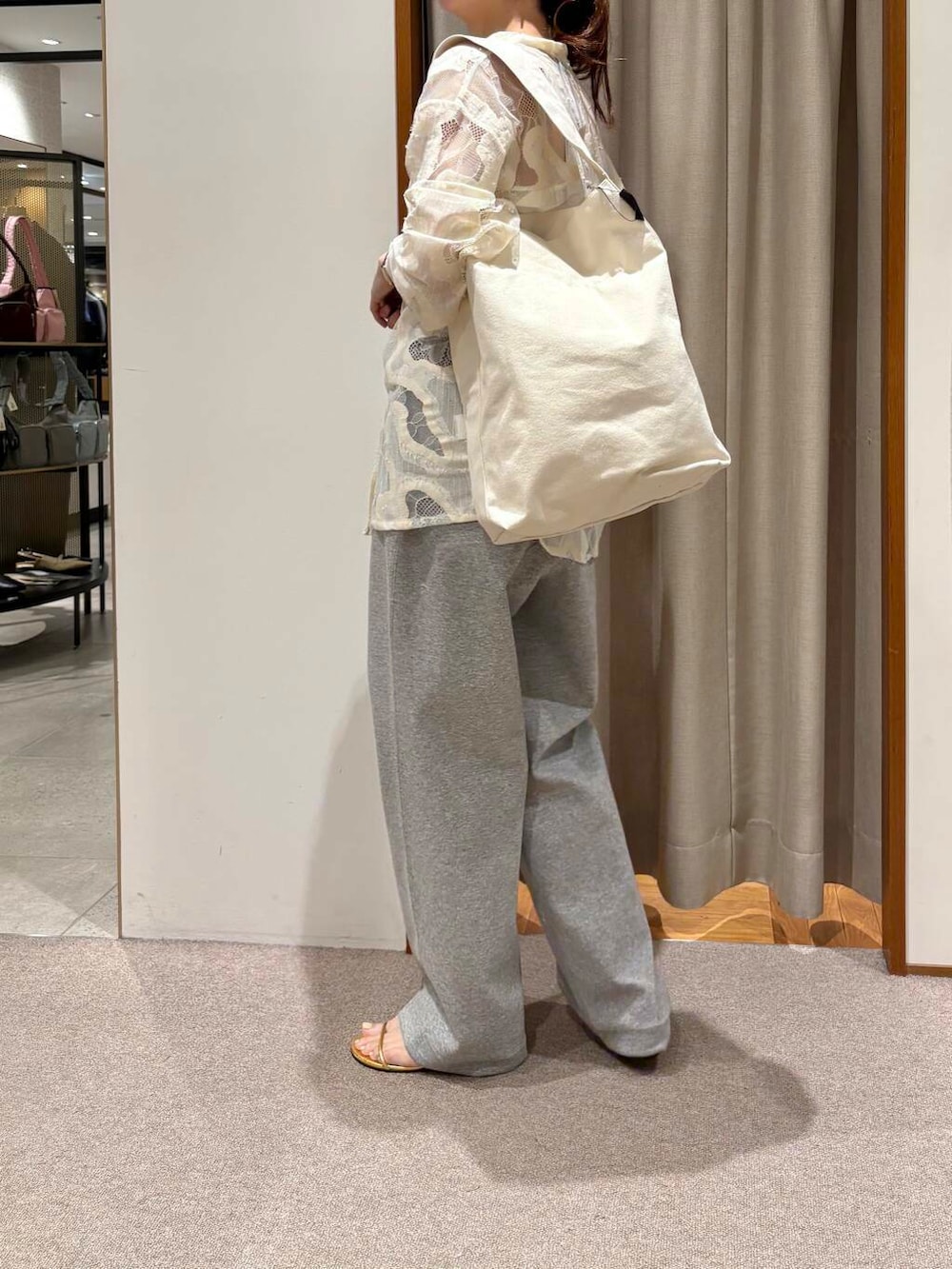 ベージュ系のトートバッグ、グレー系のその他パンツ、ゴールド系のネックレスを着用したレディースの春コーディネートの3枚目の写真