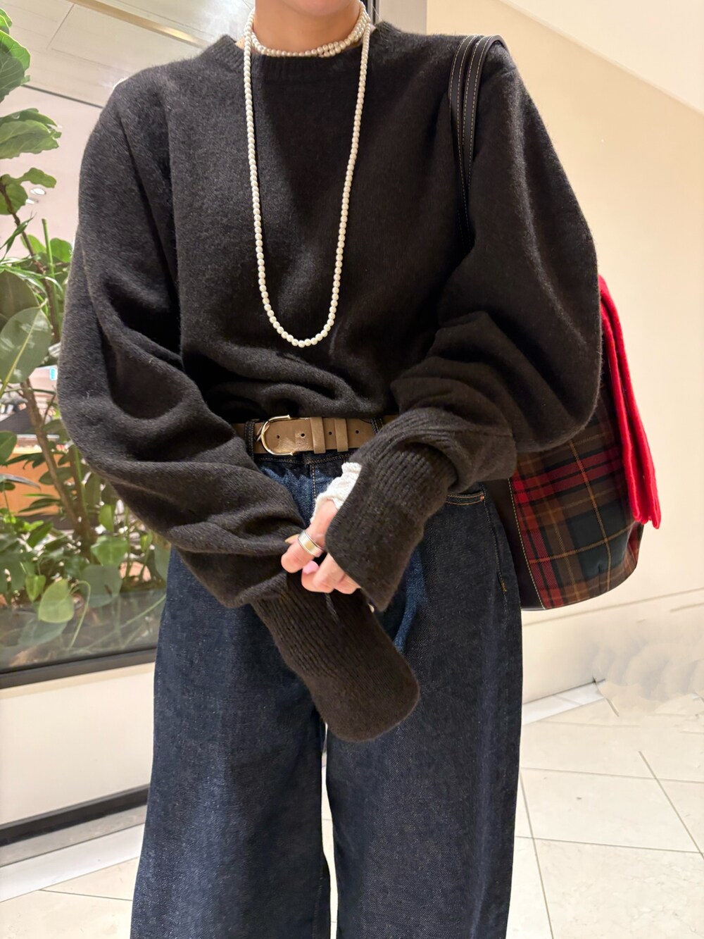 ブラウン系のニット/セーター、ブルー系のデニムパンツ、レッド系のパンプスを着用したレディースの秋コーディネートの10枚目の写真