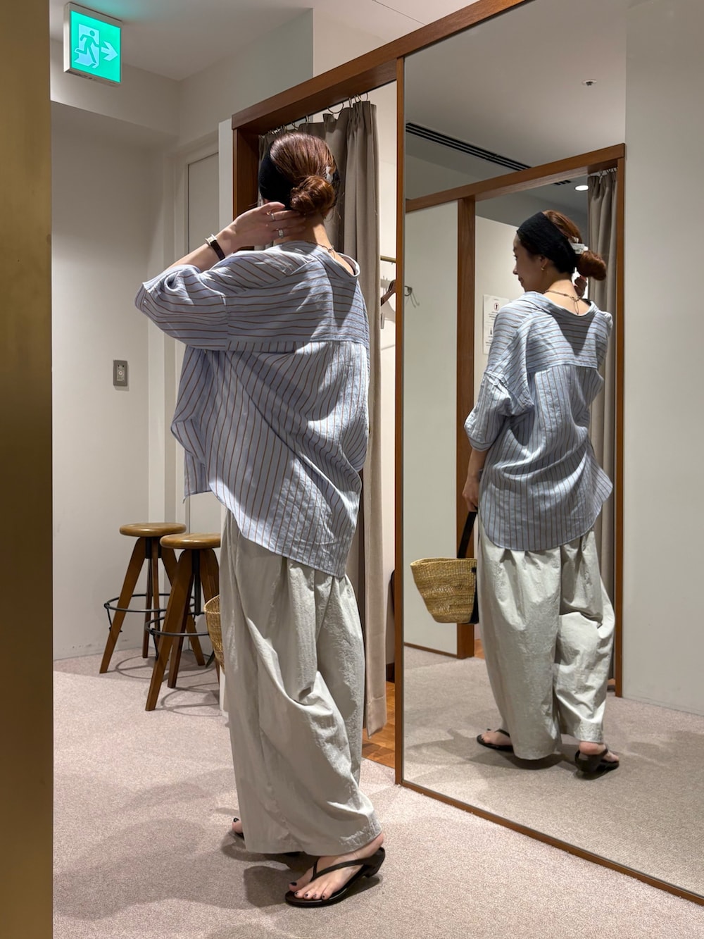 ベージュ系のかごバッグ、グレー系のその他パンツ、ブラウン系のサンダルを着用したレディースの夏コーディネートの4枚目の写真