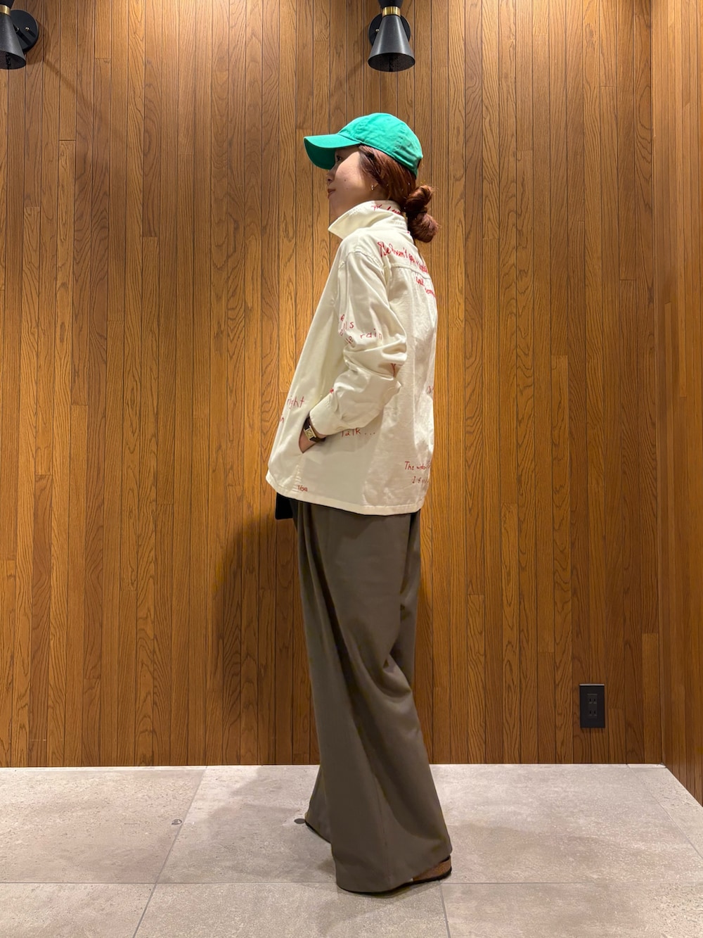 ブラック系のハンドバッグ、シルバー系のサンダル、ホワイト系のTシャツ/カットソーを着用したレディースの秋コーディネートの2枚目の写真