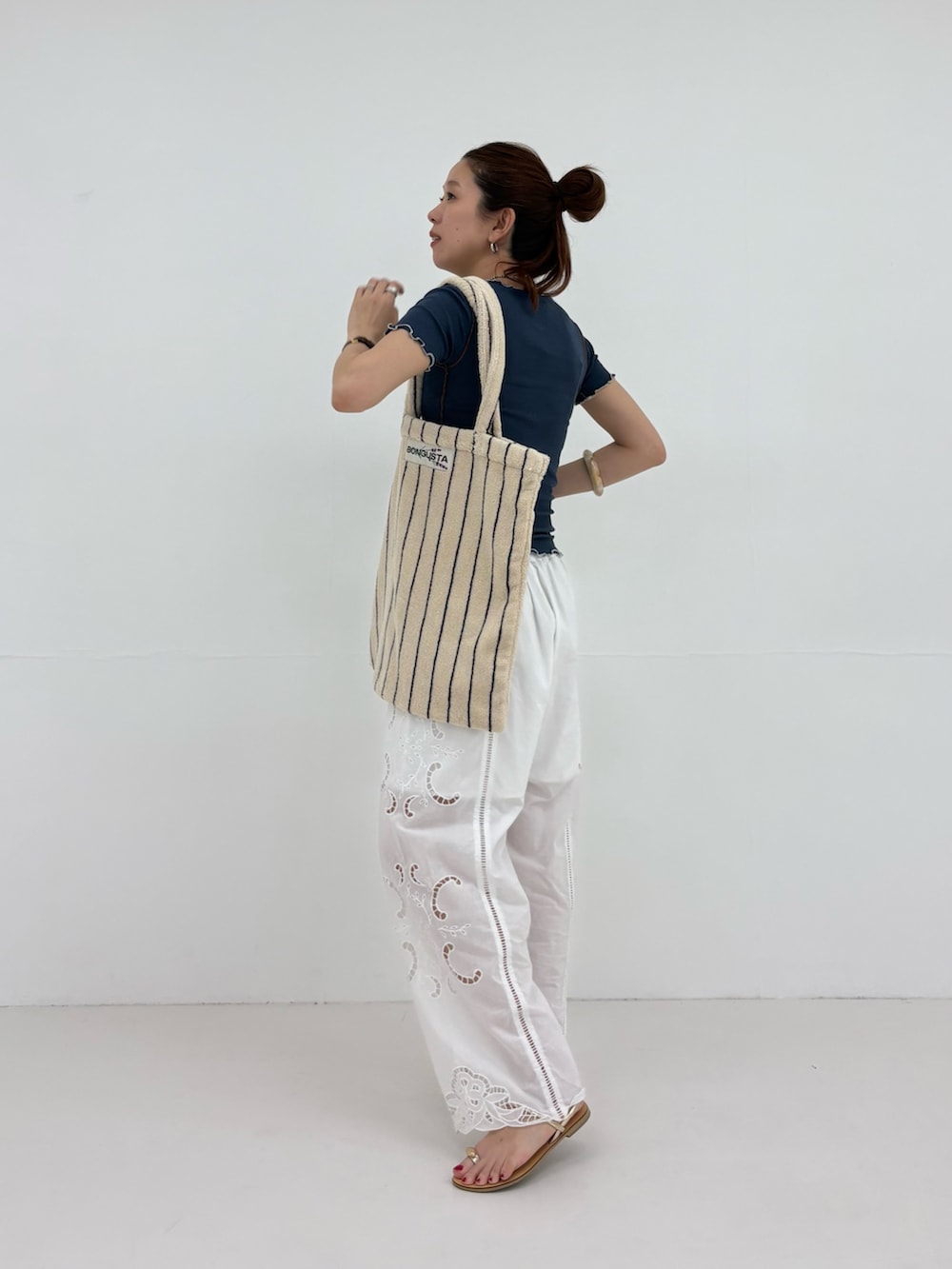 ブルー系のTシャツ/カットソー、ホワイト系のその他パンツ、ホワイト系のトートバッグを着用したレディースの春コーディネートの2枚目の写真