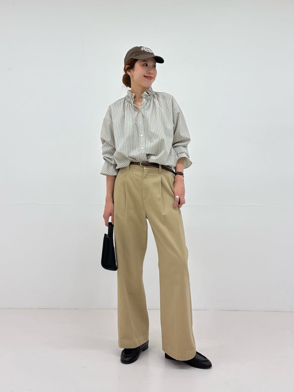 グリーン系のシャツ/ブラウス、ベージュ系のその他パンツ、ブラック系のローファーを着用したレディースの秋コーディネートの5枚目の写真