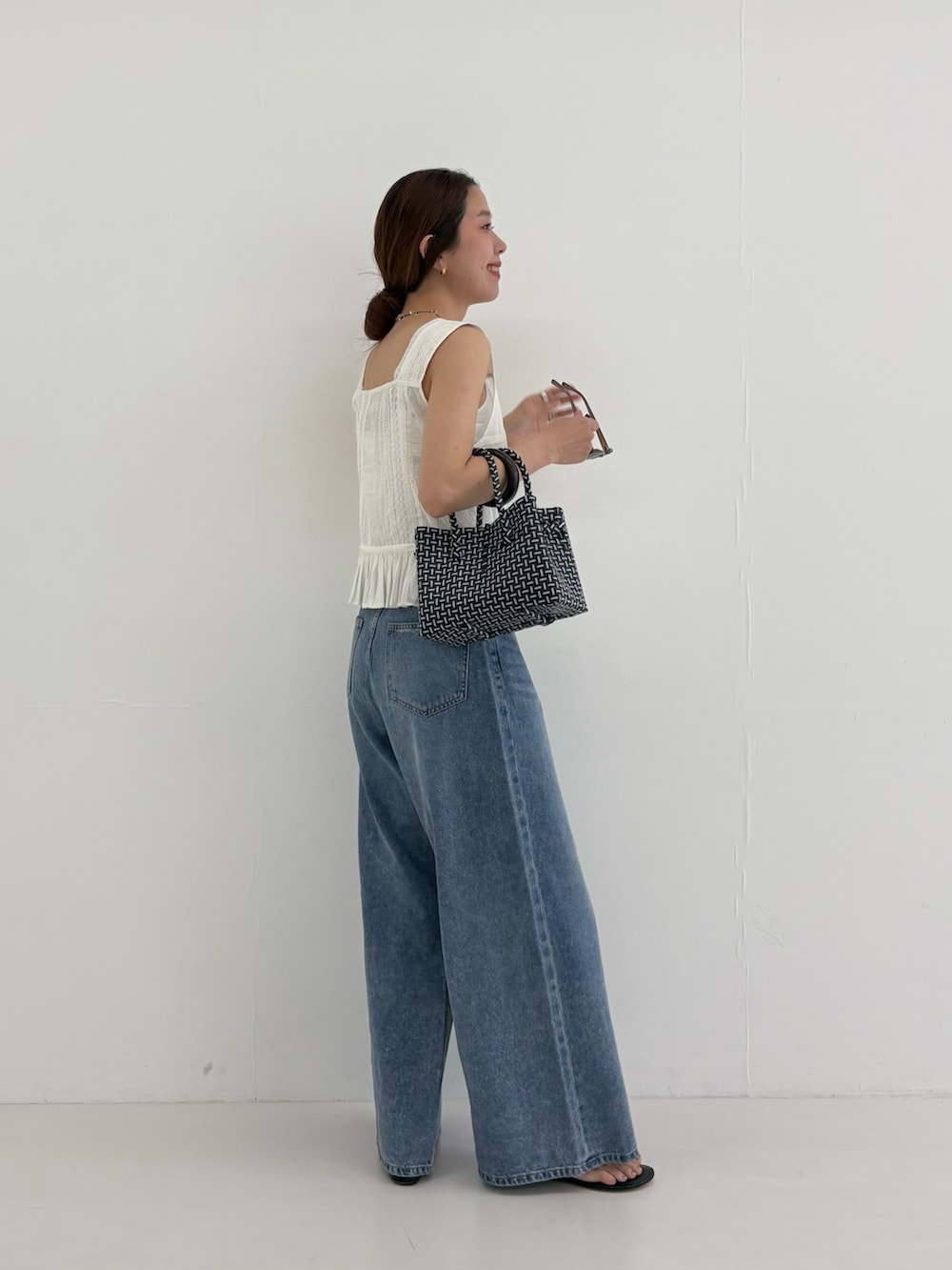 ブルー系のデニムパンツ、その他のトートバッグ、ホワイト系のシャツ/ブラウスを着用したレディースの夏コーディネートの6枚目の写真