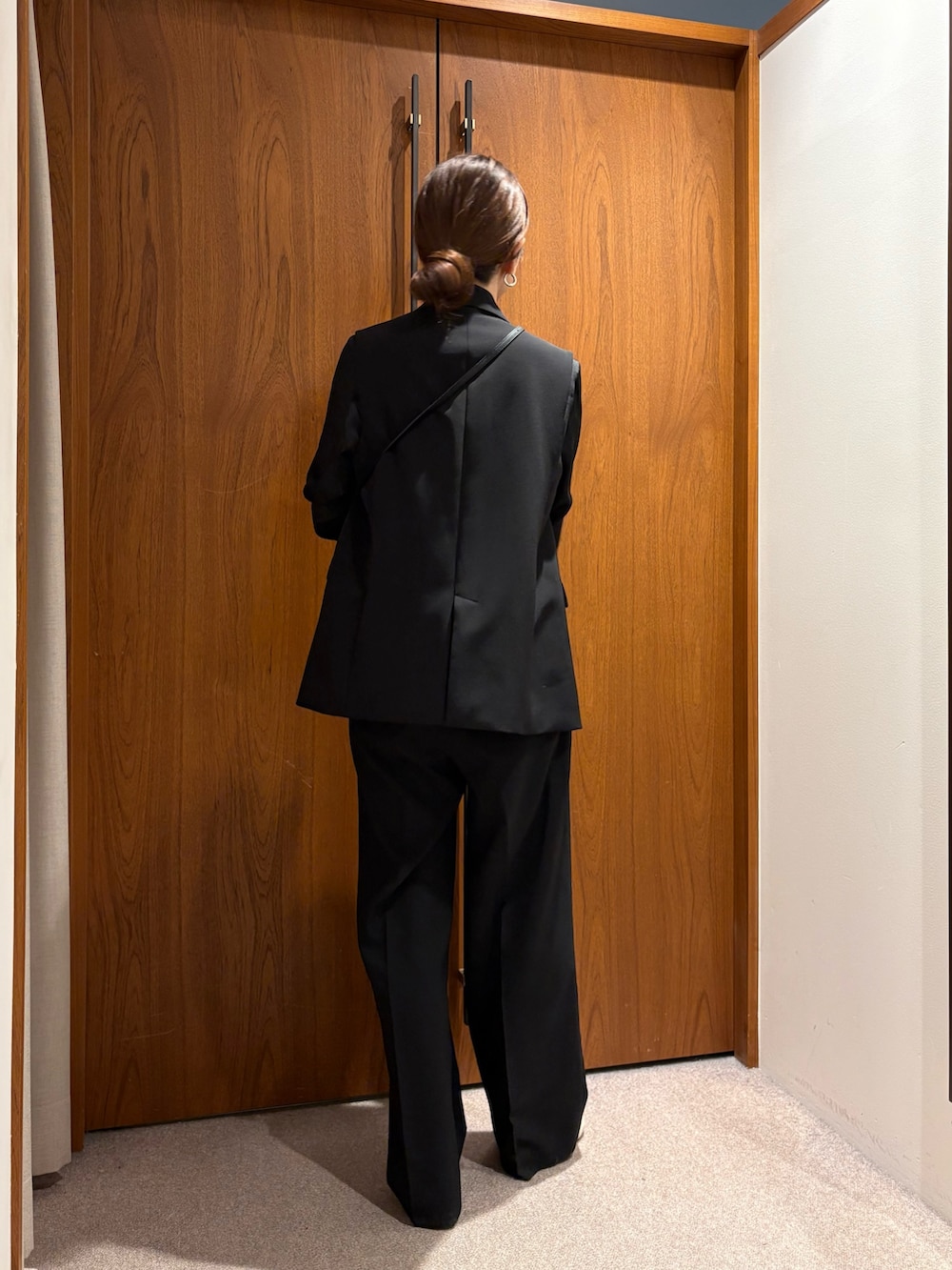 ベージュ系のトレンチコート、ブラック系のその他パンツ、ブラック系のその他アウターを着用したレディースの冬コーディネートの8枚目の写真