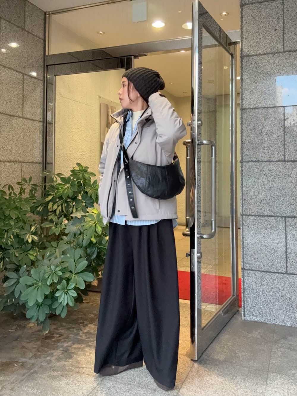 グレー系のダウンジャケット/コート、ブラック系のその他パンツ、ブラウン系のスニーカーを着用したレディースの秋コーディネートの2枚目の写真