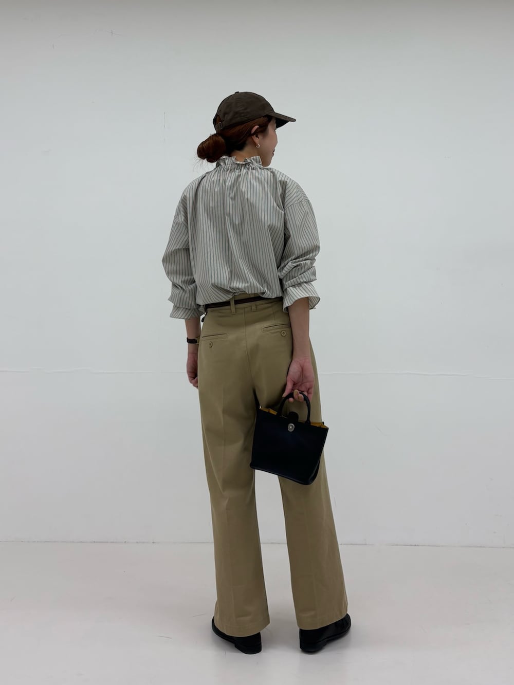 グリーン系のシャツ/ブラウス、ベージュ系のその他パンツ、ブラック系のローファーを着用したレディースの秋コーディネートの3枚目の写真