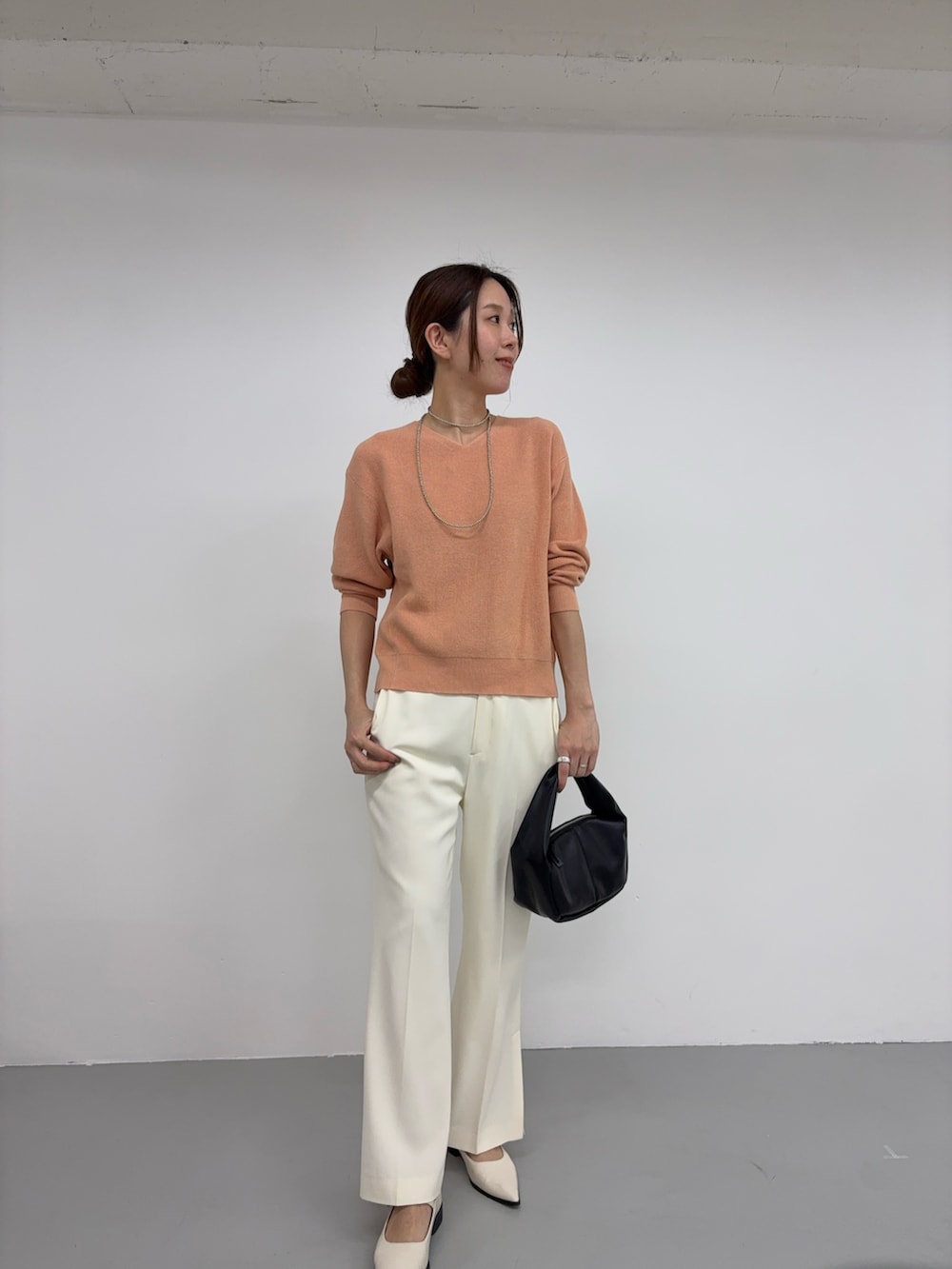 ピンク系のニット/セーター、ブラック系のハンドバッグ、ホワイト系のその他シューズを着用したレディースの冬コーディネートの3枚目の写真