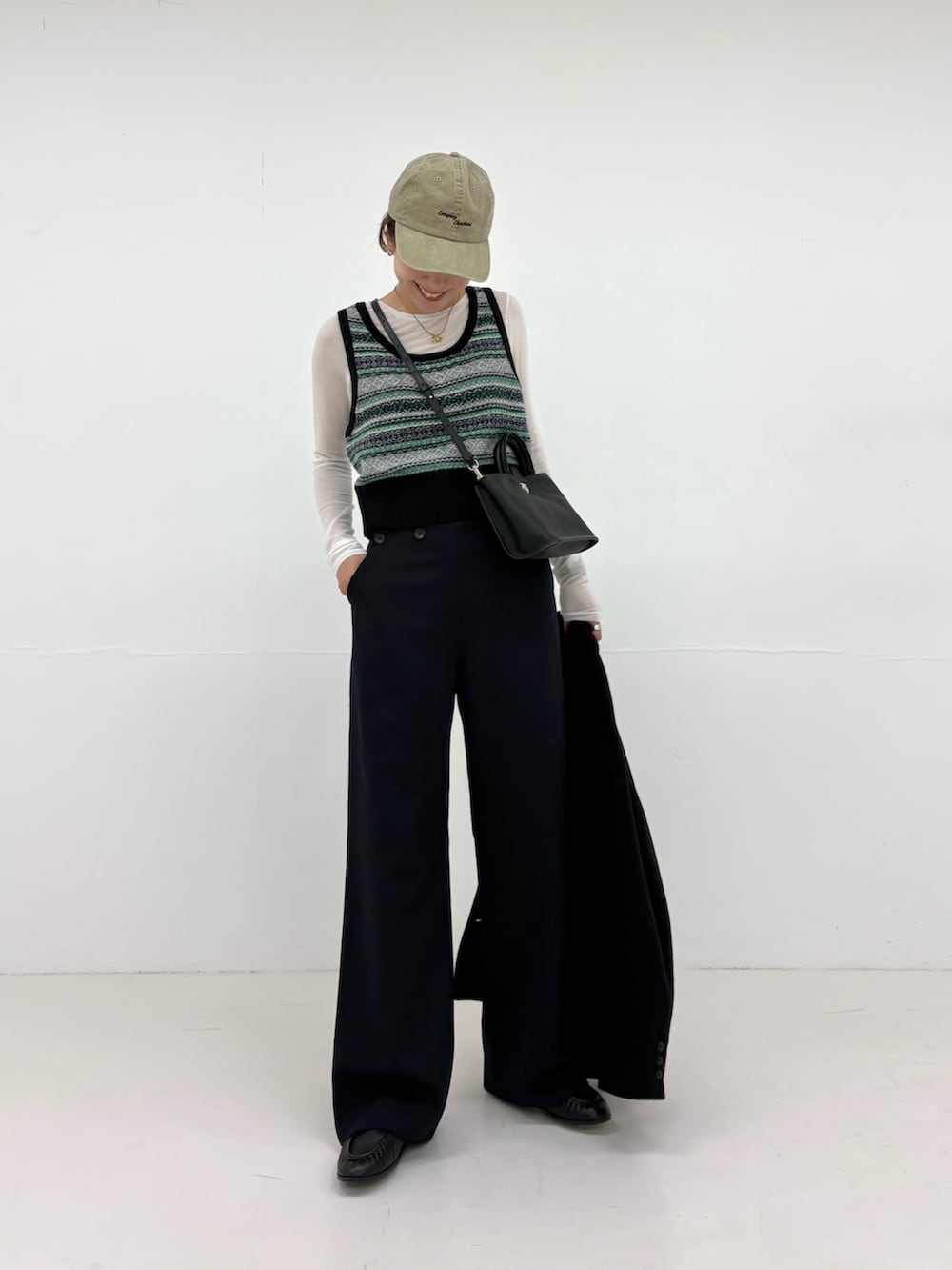 ブルー系のその他パンツ、ブラック系のハンドバッグ、ブラック系のネクタイを着用したレディースの秋コーディネートの5枚目の写真