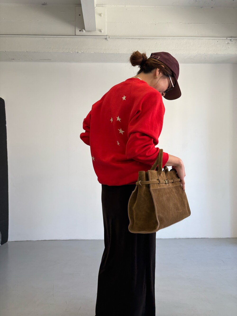 レッド系のスウェット、ブラウン系のトートバッグ、ブラック系のローファーを着用したレディースの秋コーディネートの9枚目の写真