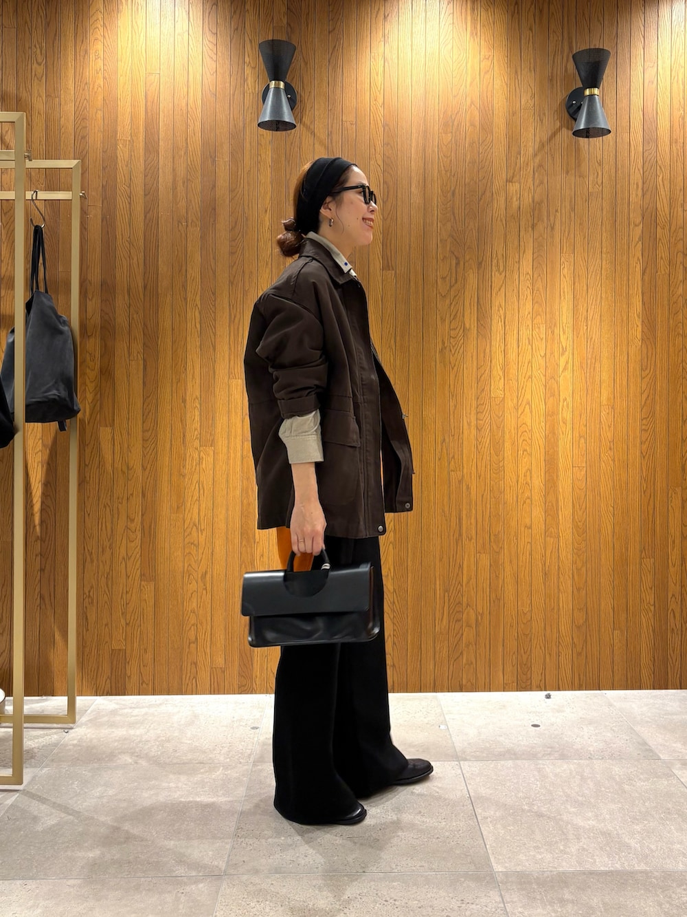 ブラウン系のカバーオール、ベージュ系のTシャツ/カットソー、ブラック系のその他パンツを着用したレディースの秋コーディネートの3枚目の写真