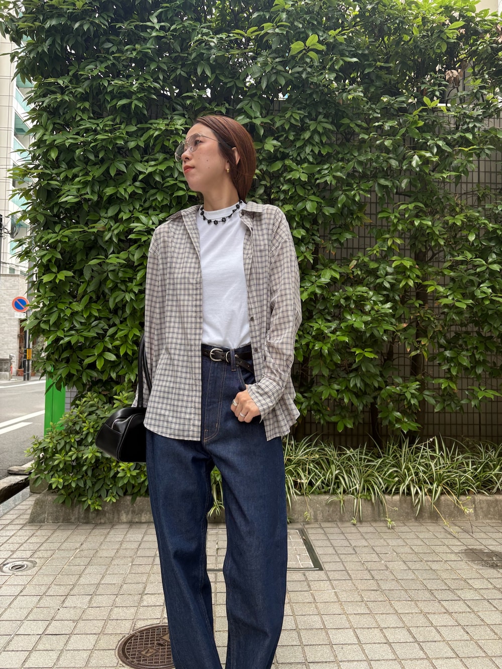 ブルー系のデニムパンツ、ブラック系のショルダーバッグ、ホワイト系のタンクトップを着用したレディースの夏コーディネートの8枚目の写真