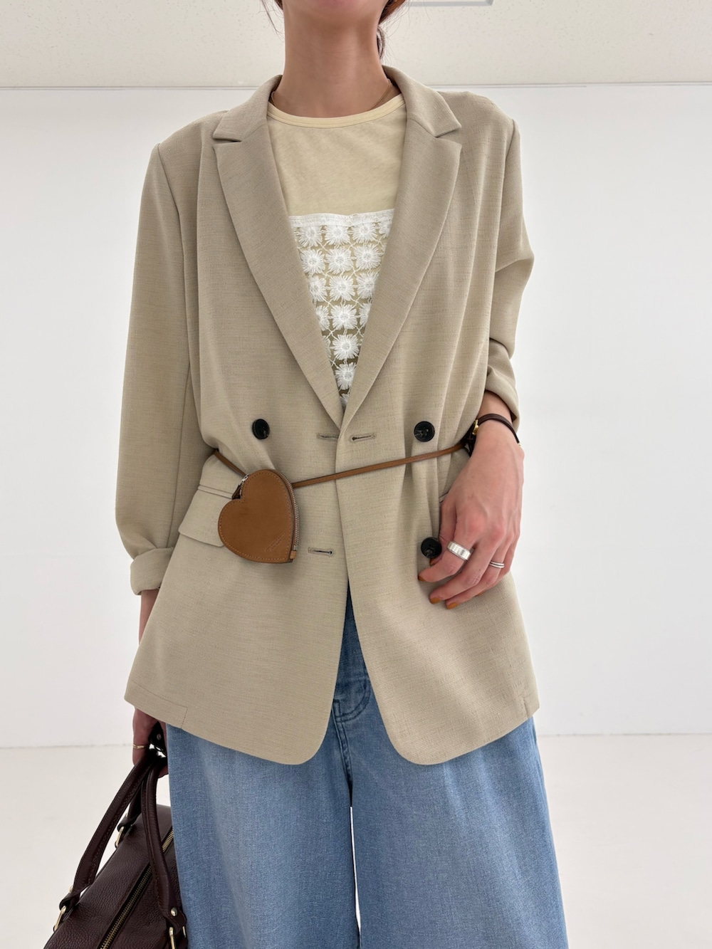 ベージュ系のその他アウター、イエロー系のTシャツ/カットソー、ブルー系のデニムパンツを着用したレディースの春コーディネートの7枚目の写真