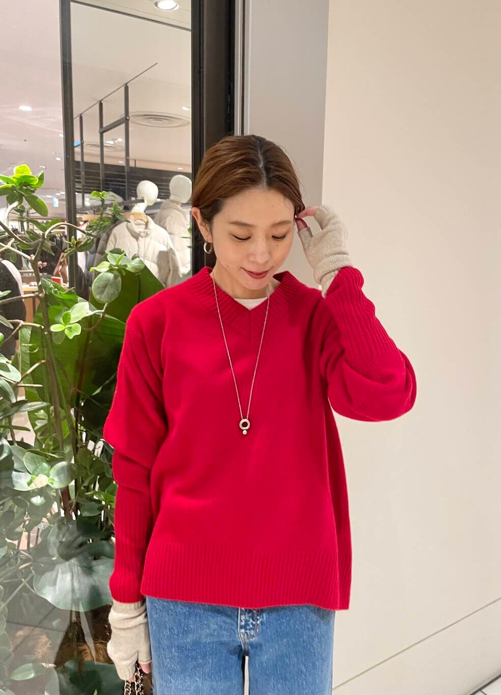 ブルー系のデニムパンツ、ブラック系のショルダーバッグ、レッド系のニット/セーターを着用したレディースの冬コーディネートの7枚目の写真