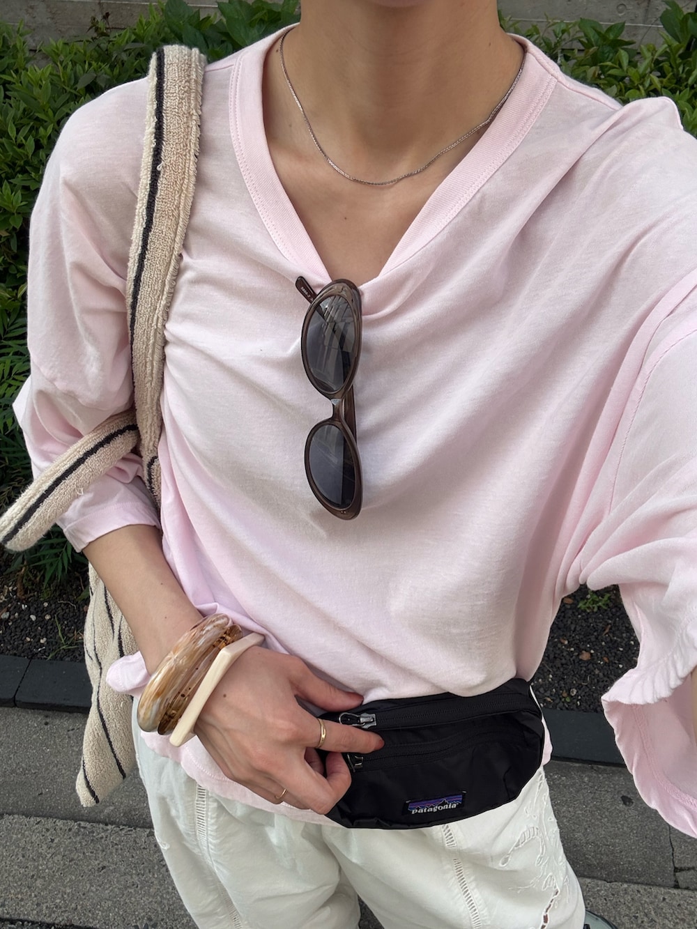 ピンク系のTシャツ/カットソー、グリーン系のスニーカー、ブラック系のボディバッグ/ウエストポーチを着用したレディースの春コーディネートの9枚目の写真