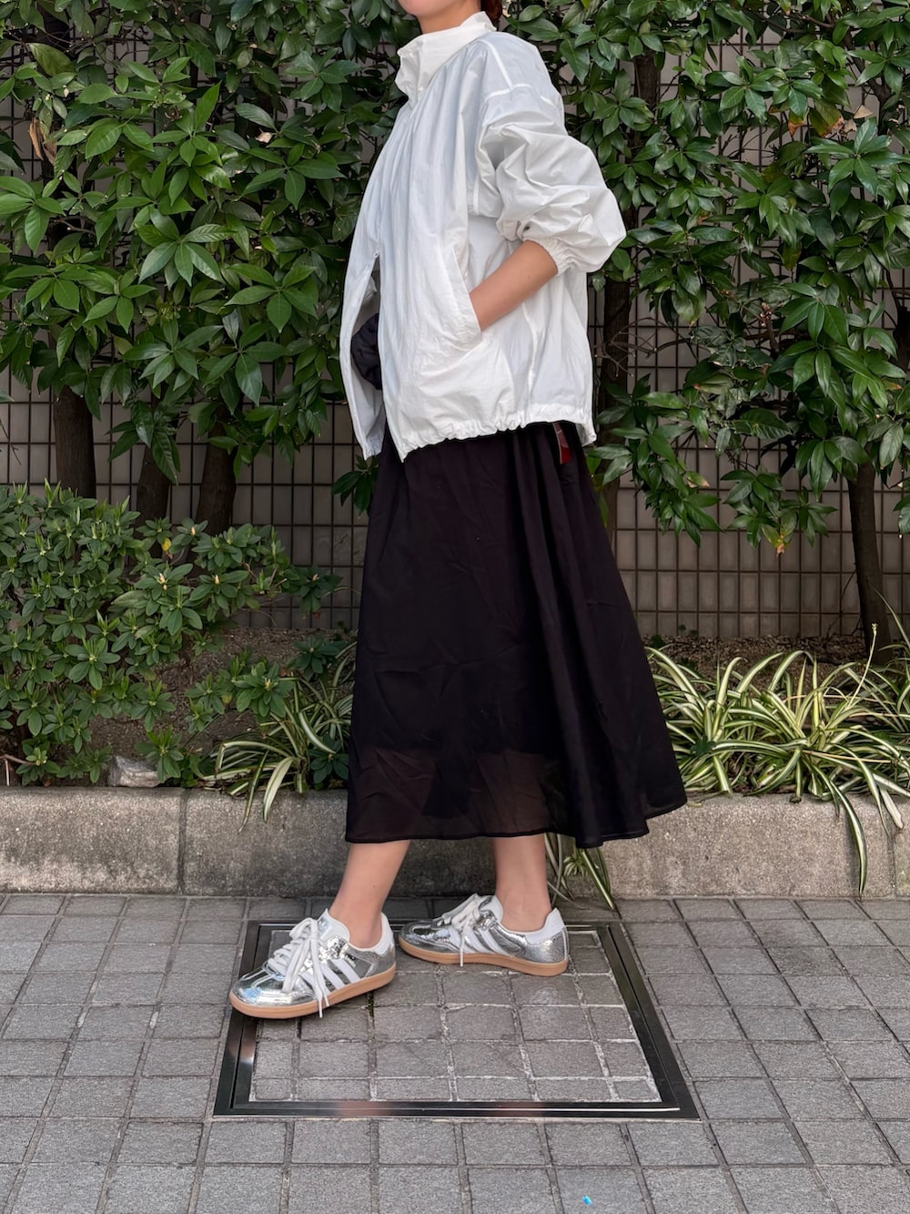 ホワイト系のブルゾン、ブラック系のワンピース、ブラック系のボディバッグ/ウエストポーチを着用したレディースの春コーディネートの3枚目の写真