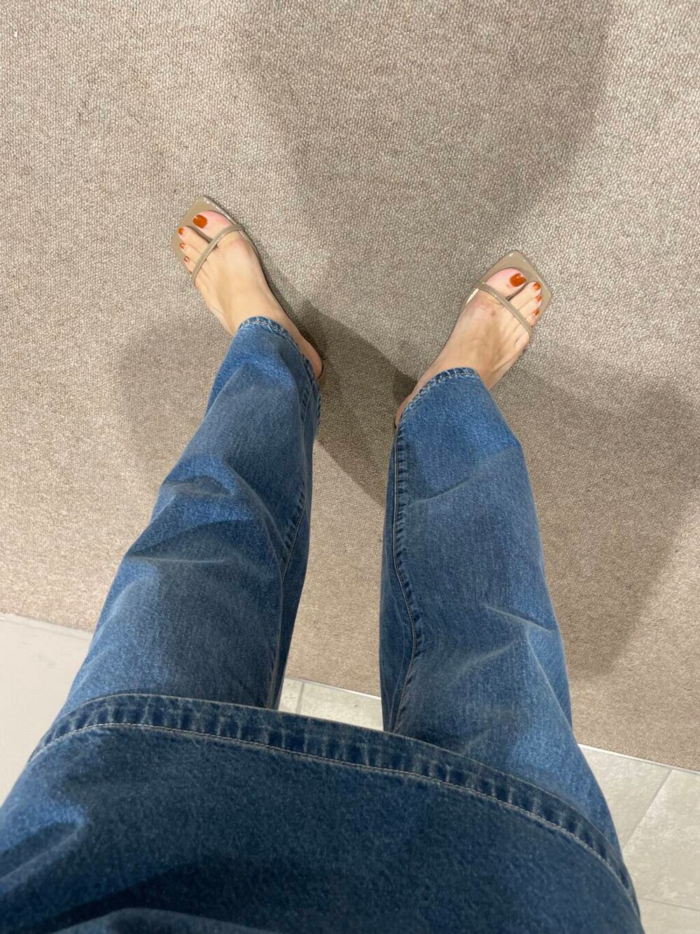 ホワイト系のタンクトップ、ブルー系のベスト、ブルー系のデニムパンツを着用したレディースの夏コーディネートの5枚目の写真