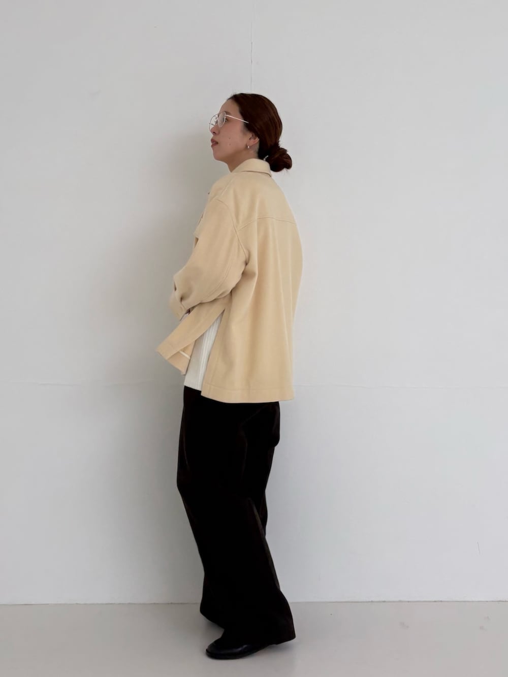 ホワイト系のニット/セーター、ブラウン系のその他パンツ、ゴールド系のメガネを着用したレディースの秋コーディネートの3枚目の写真