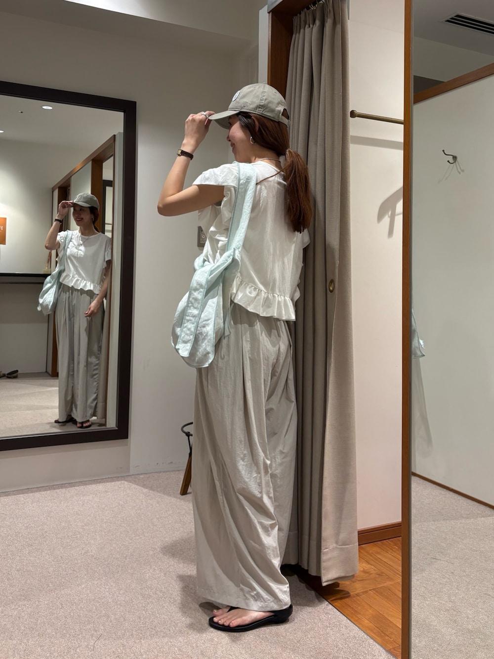 ホワイト系のTシャツ/カットソー、グレー系のその他パンツ、ブラック系のサンダルを着用したレディースの夏コーディネートの2枚目の写真