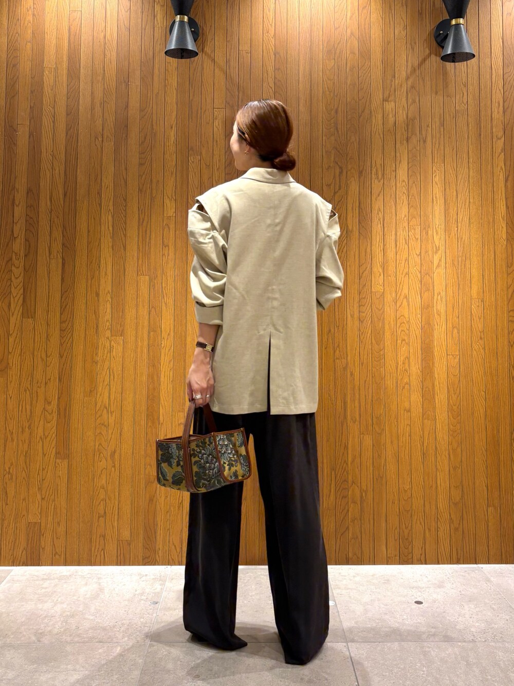 ホワイト系のその他アウター、ブラウン系のその他パンツ、ベージュ系のハンドバッグを着用したレディースの秋コーディネートの5枚目の写真