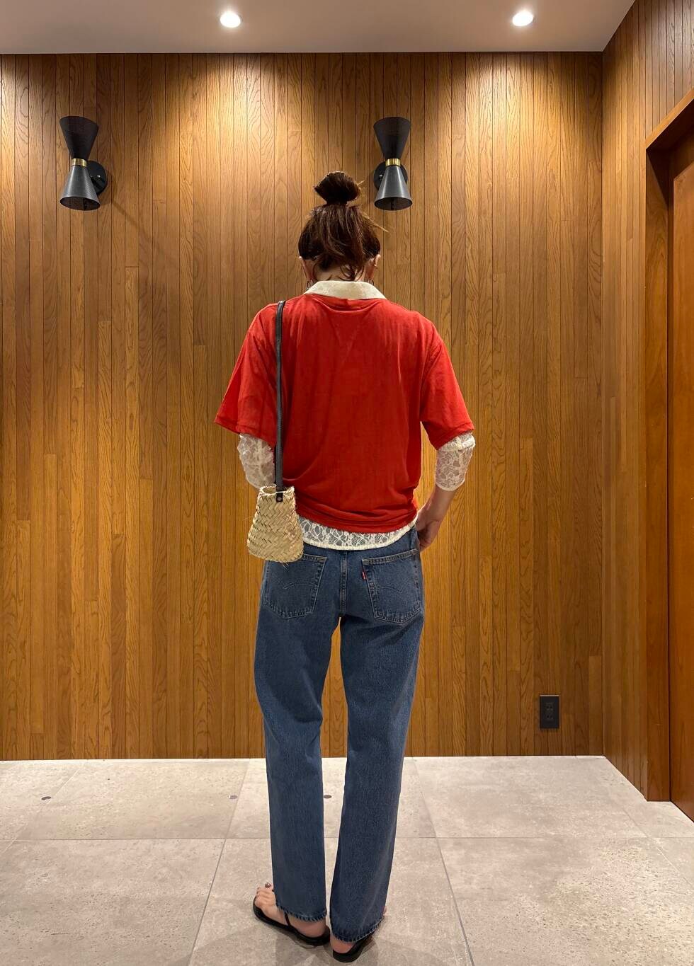 ブルー系のデニムパンツ、ブラック系のサンダル、レッド系のTシャツ/カットソーを着用したレディースの夏コーディネートの5枚目の写真