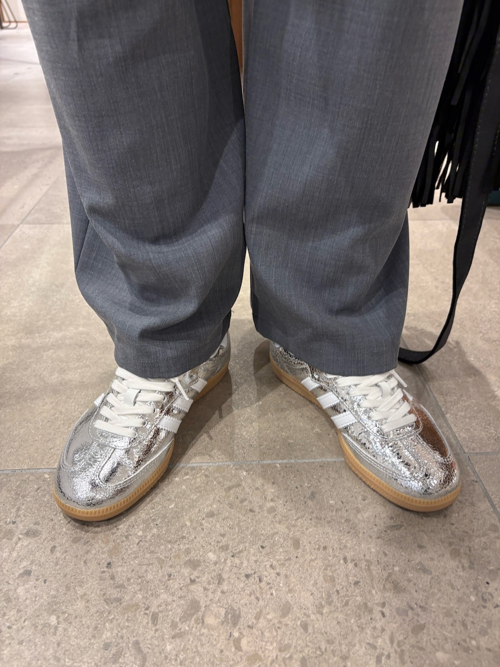 グレー系のその他パンツ、シルバー系のスニーカー、ブラック系のハンドバッグを着用したレディースの春コーディネートの6枚目の写真