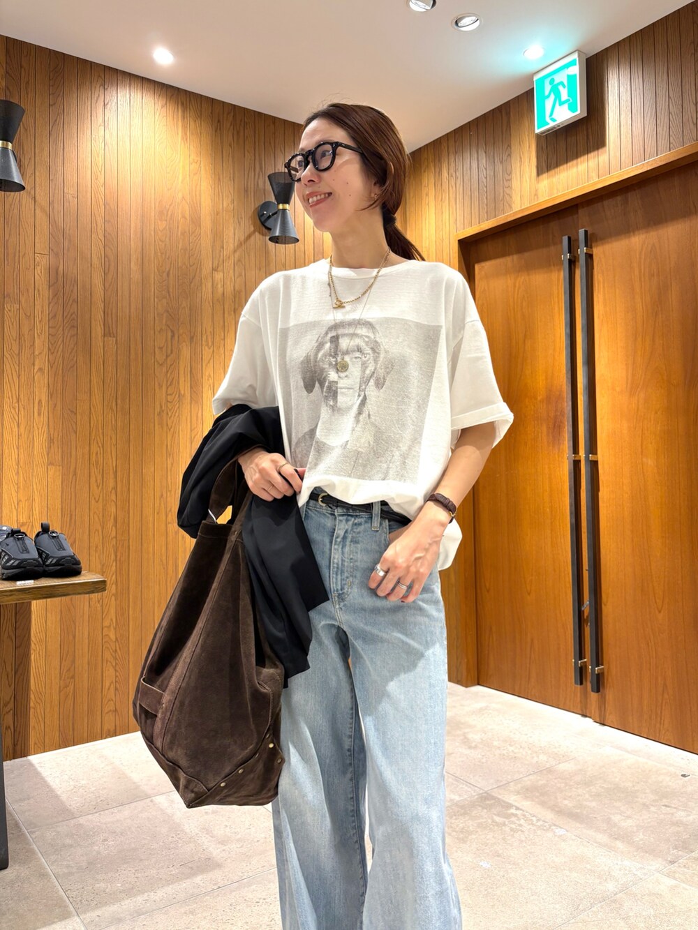 ブルー系のデニムパンツ、ホワイト系のTシャツ/カットソー、ブラック系のテーラードジャケットを着用したレディースの夏コーディネートの5枚目の写真