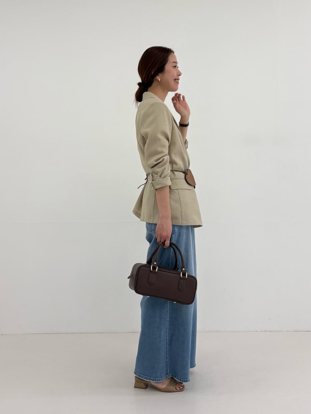 ベージュ系のその他アウター、イエロー系のTシャツ/カットソー、ブルー系のデニムパンツを着用したレディースの春コーディネートの5枚目の写真