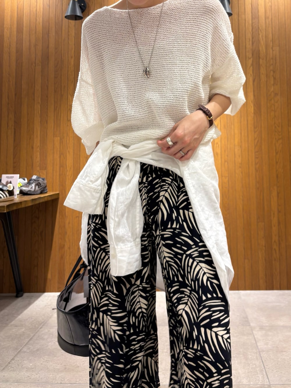 ホワイト系のニット/セーター、ブラック系のその他パンツ、ブラック系のかごバッグを着用したレディースの春コーディネートの5枚目の写真