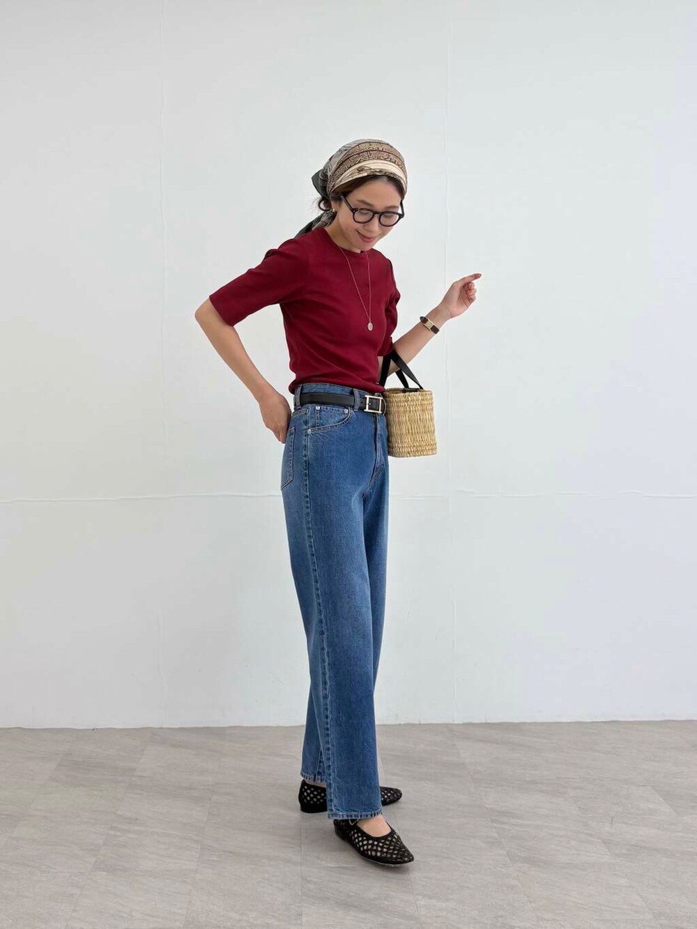 ブラック系のかごバッグ、ブルー系のデニムパンツ、レッド系のTシャツ/カットソーを着用したレディースの夏コーディネートの5枚目の写真