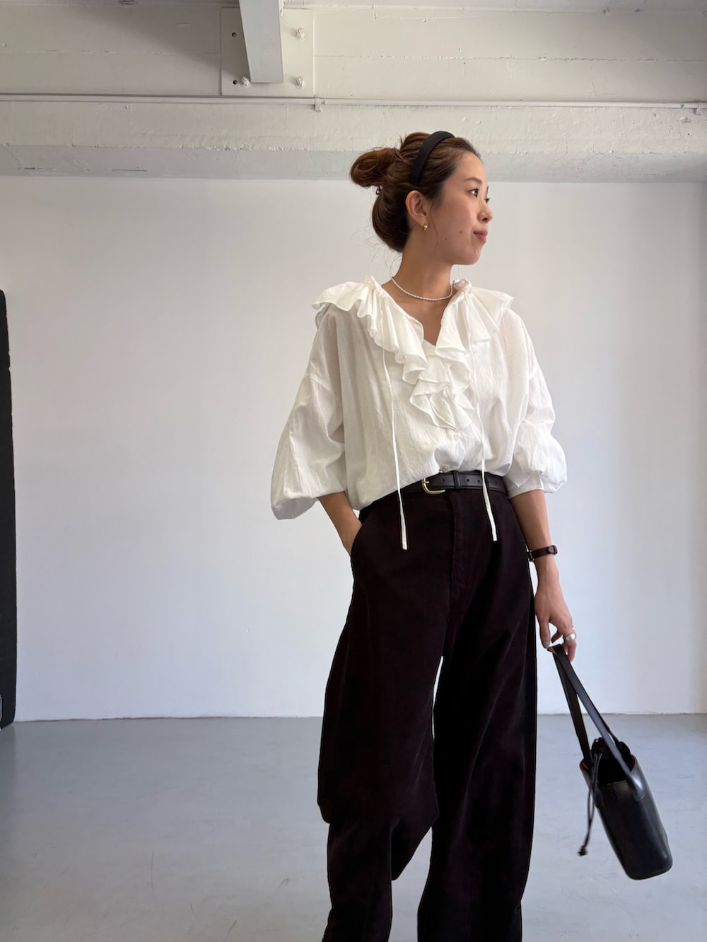 グレー系のその他パンツ、ホワイト系のシャツ/ブラウス、ブラック系のハンドバッグを着用したレディースの秋コーディネートの8枚目の写真