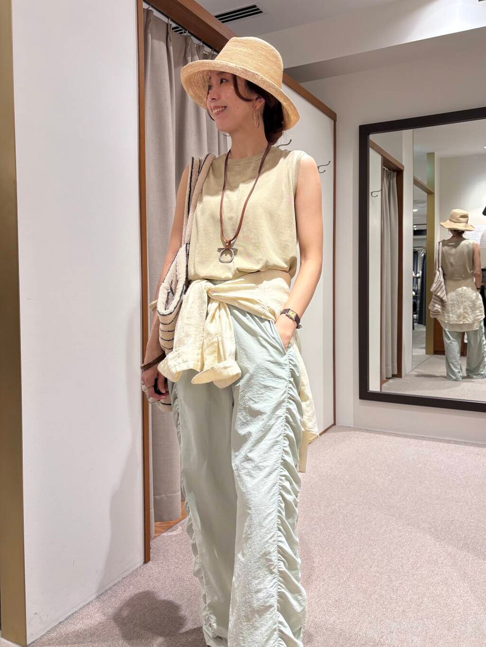 グリーン系のその他パンツ、ホワイト系のシャツ/ブラウス、ベージュ系のタンクトップを着用したレディースの夏コーディネートの7枚目の写真