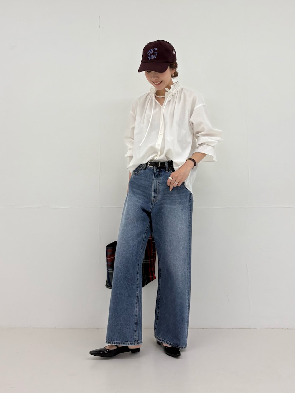 グレー系のトートバッグ、ブラック系のパンプス、ブルー系のデニムパンツを着用したレディースの夏コーディネートの5枚目の写真