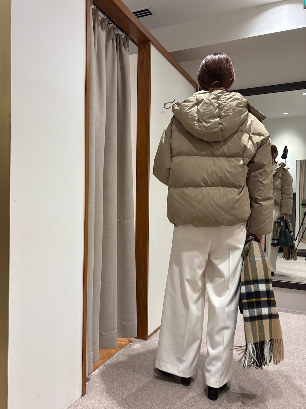 ベージュ系のダウンジャケット/コート、グリーン系のニット/セーター、ホワイト系のその他パンツを着用したレディースの秋コーディネートの4枚目の写真