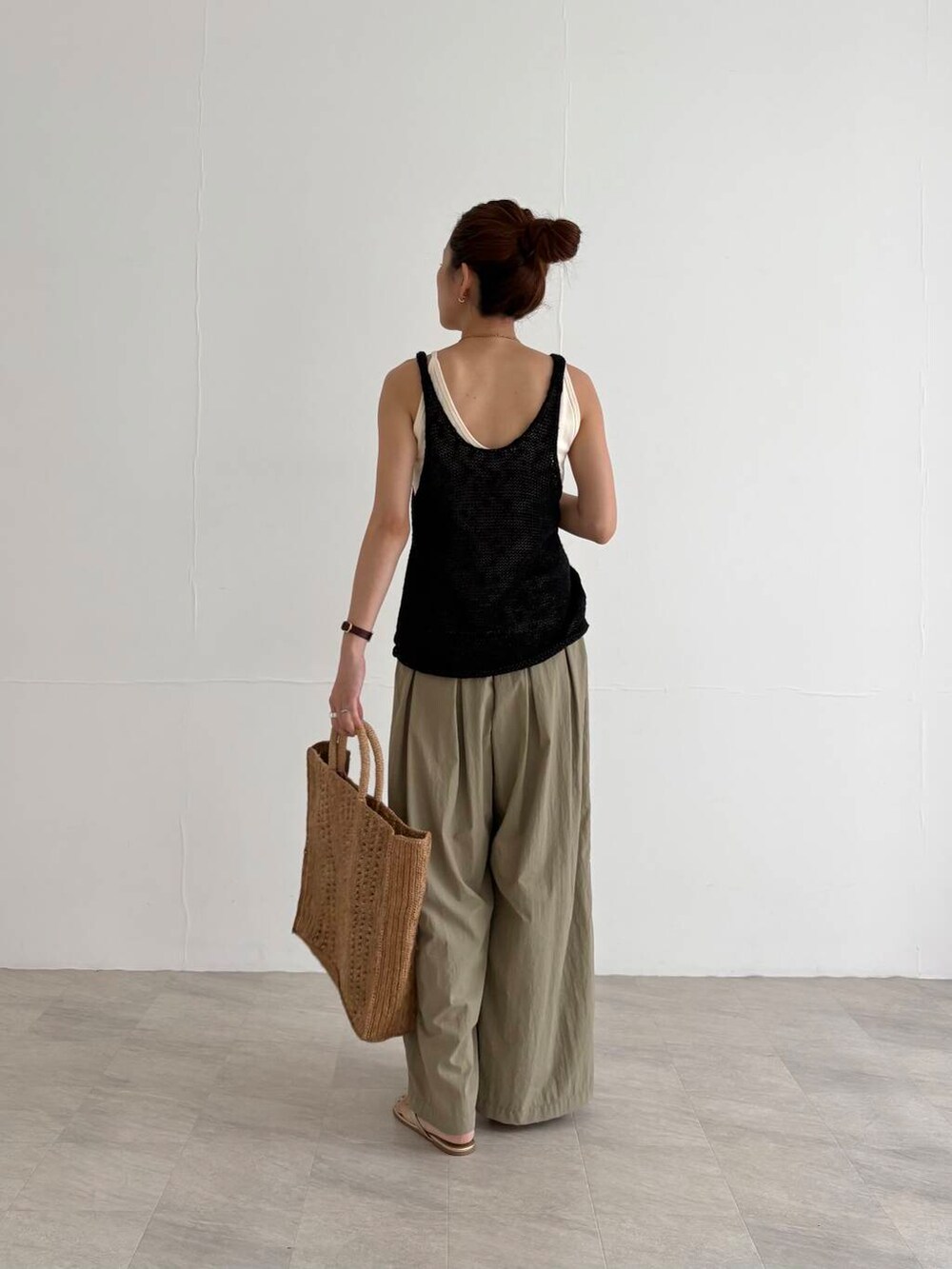 ベージュ系のその他パンツ、ホワイト系のキャミソール、ブラック系のニット/セーターを着用したレディースの夏コーディネートの3枚目の写真