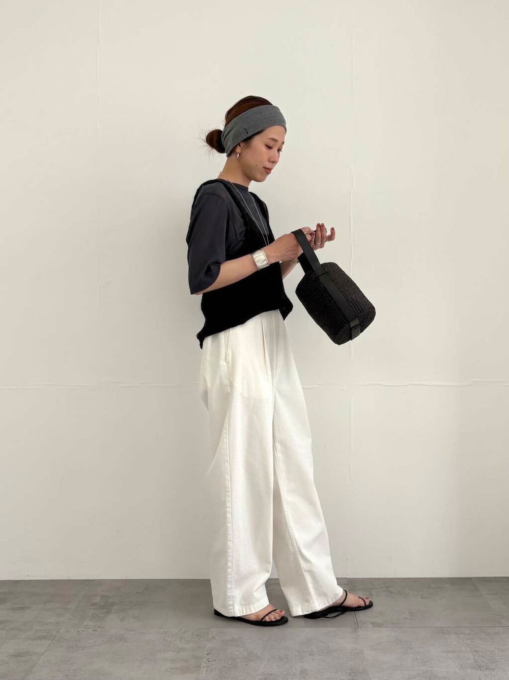 ブラック系のかごバッグ、ホワイト系のその他パンツ、ブラック系のサンダルを着用したレディースの夏コーディネートの5枚目の写真