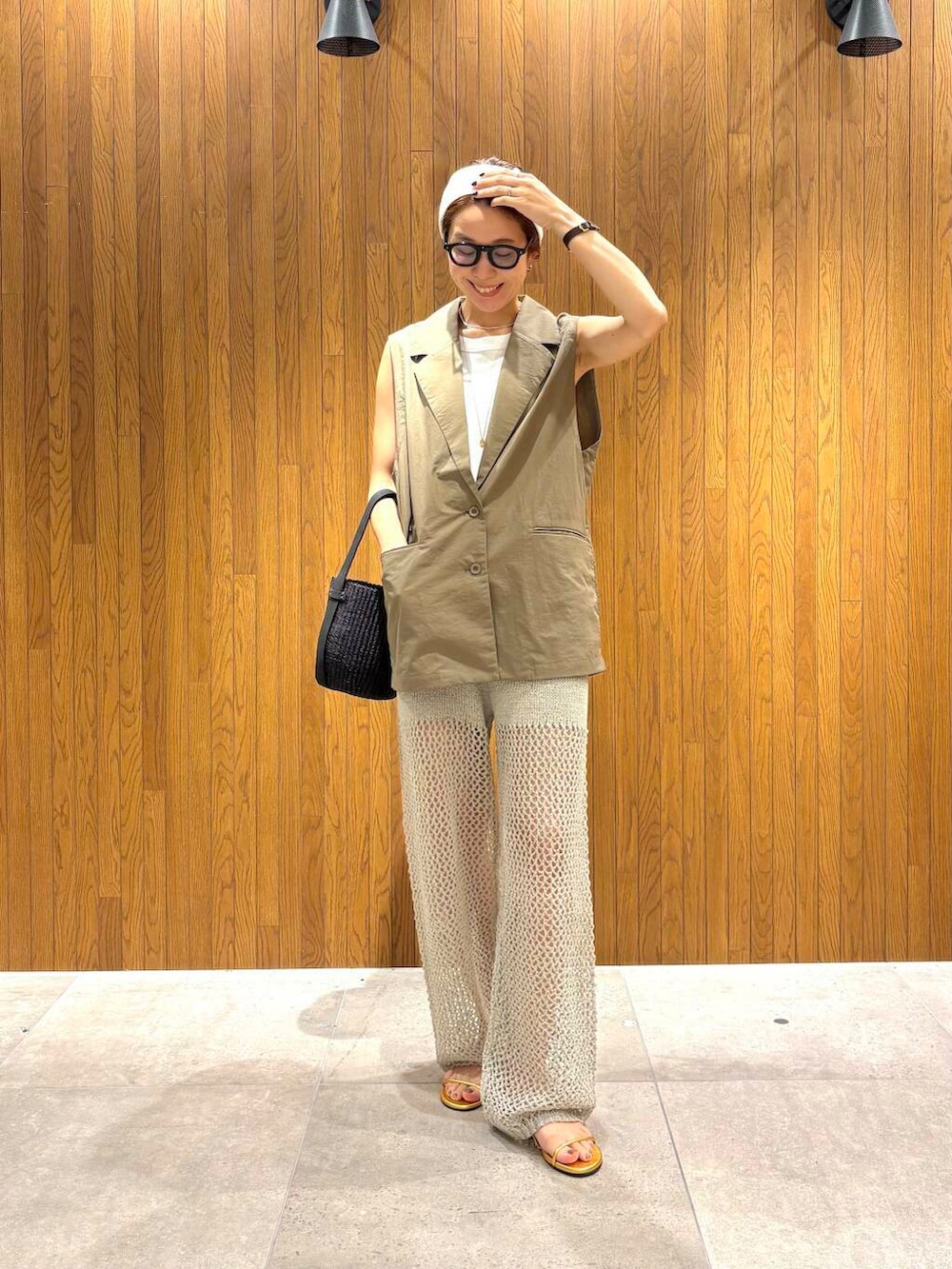 ブラック系のかごバッグ、ゴールド系のサンダル、グレー系のその他パンツを着用したレディースの夏コーディネートの2枚目の写真