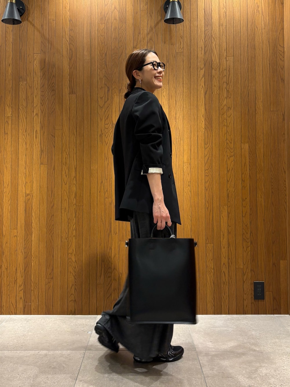 グレー系のワンピース、ブラック系のTシャツ/カットソー、ブラック系のハンドバッグを着用したレディースの冬コーディネートの4枚目の写真