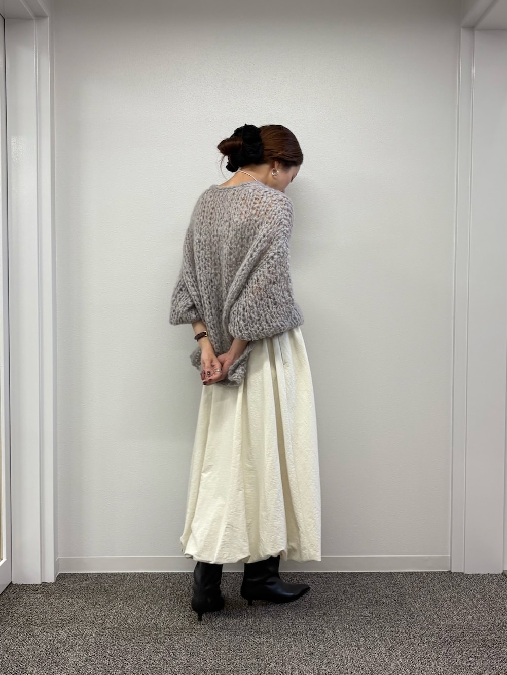 ホワイト系のスカート、ブラック系のブーツ、グレー系のニット/セーターを着用したレディースの秋コーディネートの4枚目の写真