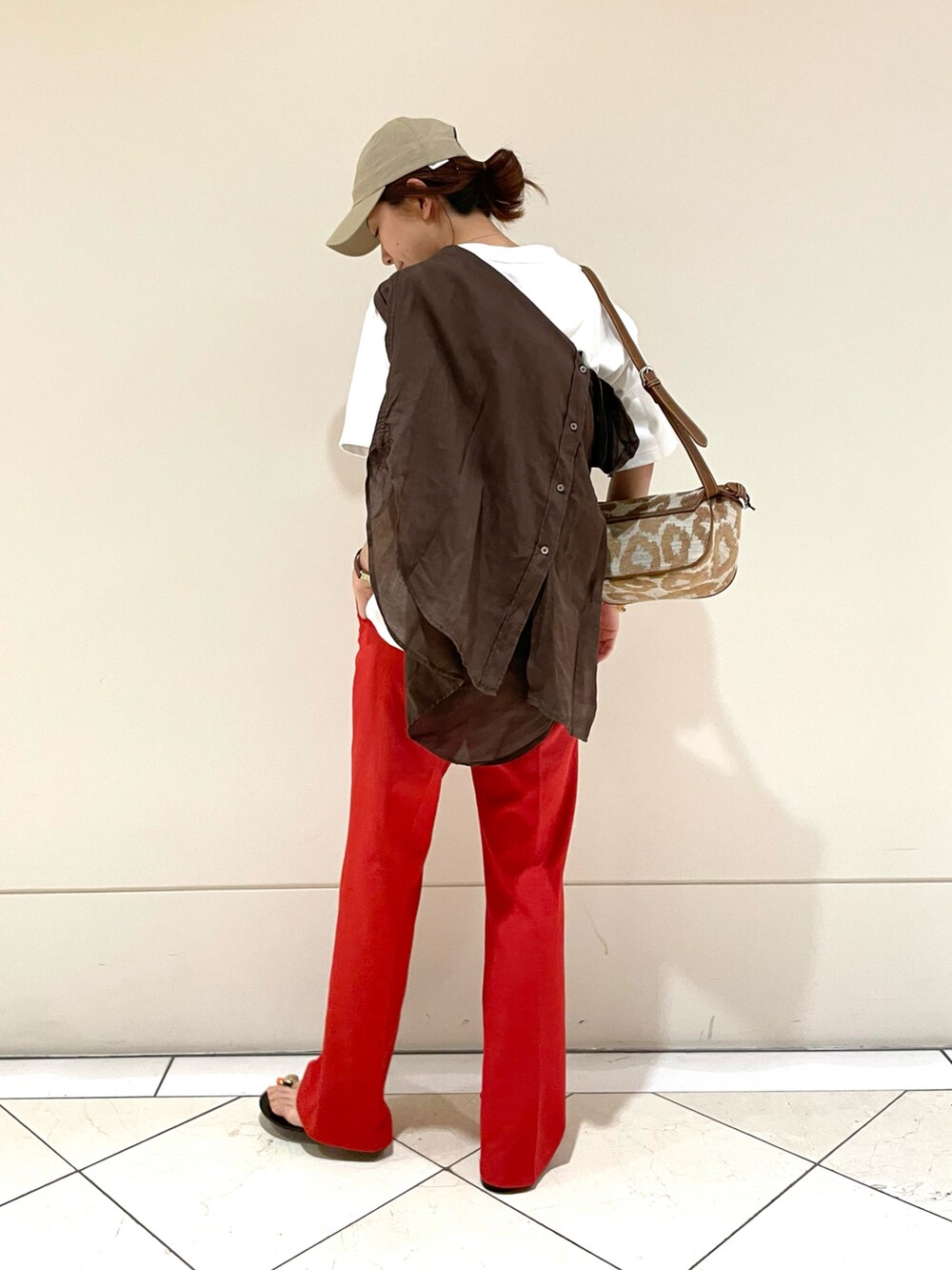 レッド系のその他パンツ、ホワイト系のTシャツ/カットソー、ブラウン系のバッグを着用したレディースの春コーディネートの2枚目の写真