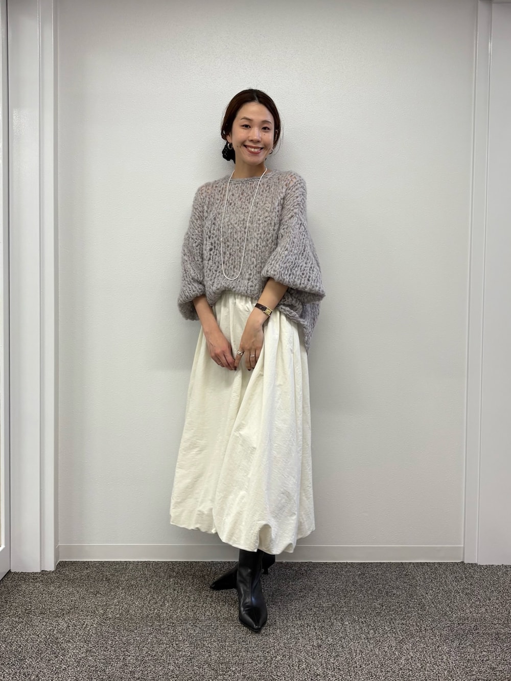 ホワイト系のスカート、ブラック系のブーツ、グレー系のニット/セーターを着用したレディースの秋コーディネートの7枚目の写真