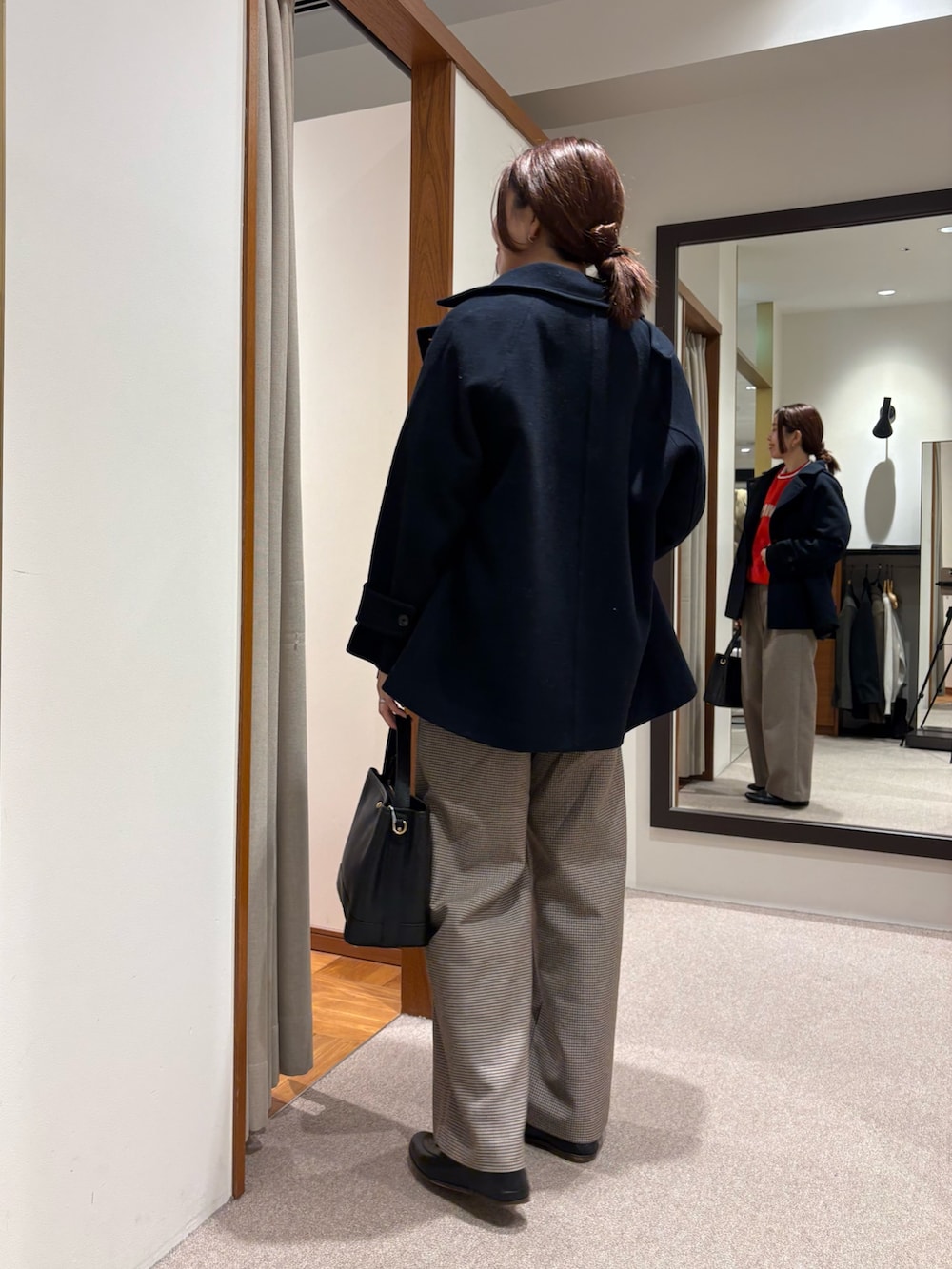 グレー系のピーコート、レッド系のスウェット、イエロー系のその他パンツを着用したレディースの秋コーディネートの3枚目の写真