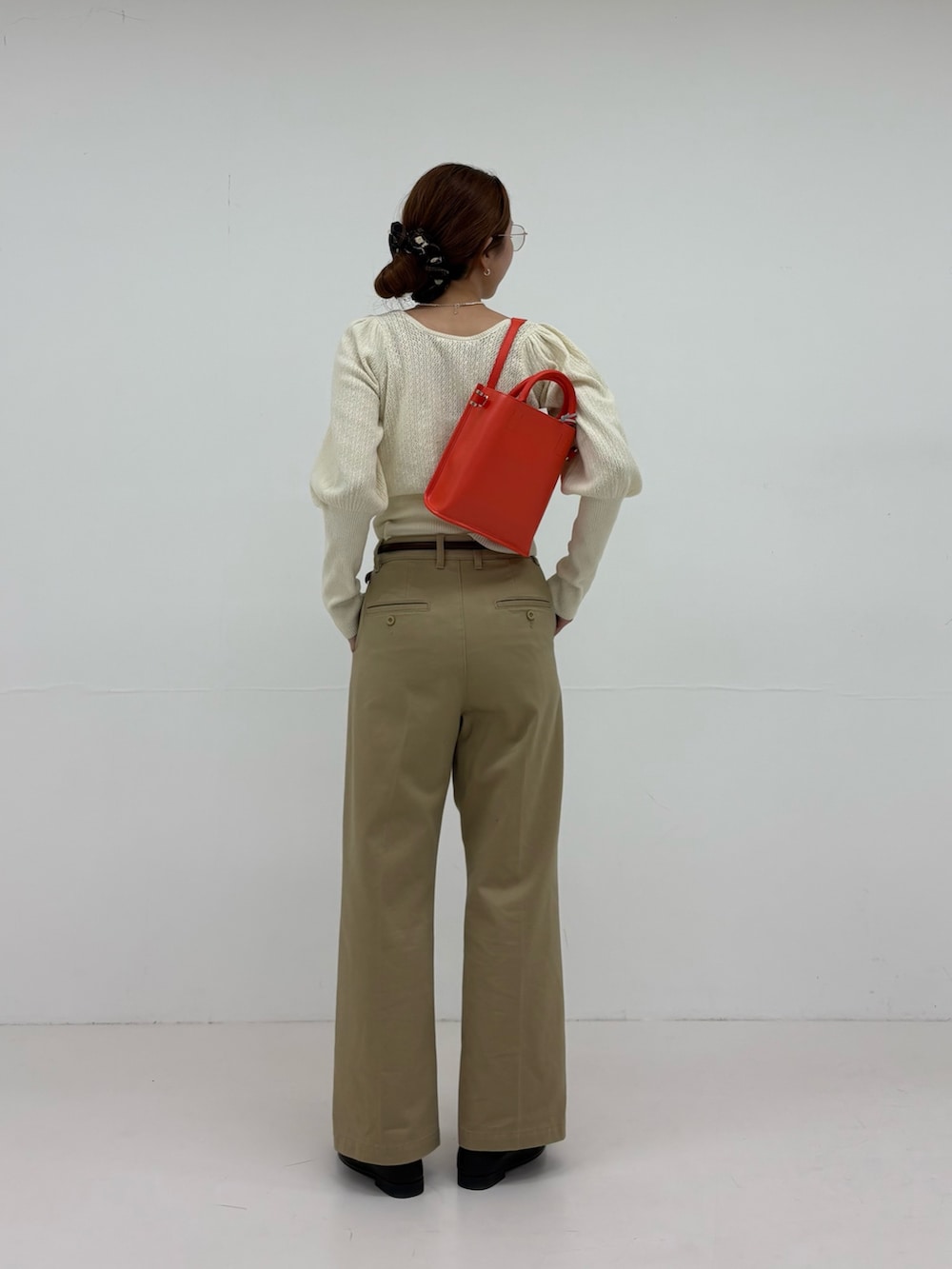 ホワイト系のニット/セーター、ベージュ系のその他パンツ、ブラック系のローファーを着用したレディースの夏コーディネートの3枚目の写真