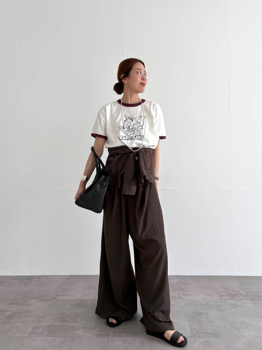 ブラウン系のサロペット/オーバーオール、ホワイト系のTシャツ/カットソー、ブラック系のサンダルを着用したレディースの春コーディネートの2枚目の写真