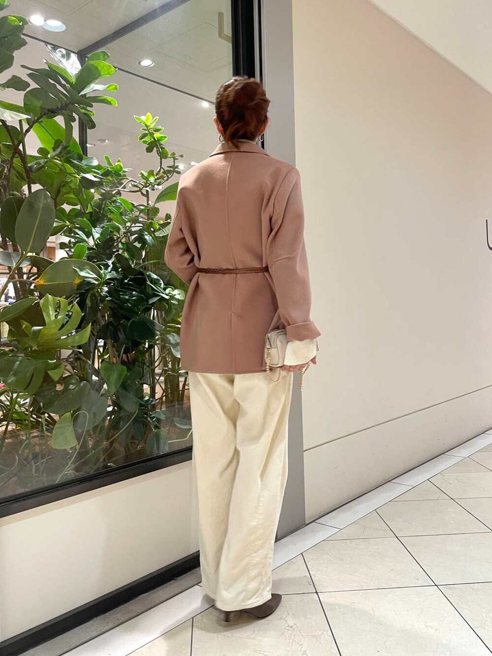 ホワイト系のニット/セーター、ベージュ系のその他アウター、ブラウン系のブーツを着用したレディースの秋コーディネートの3枚目の写真