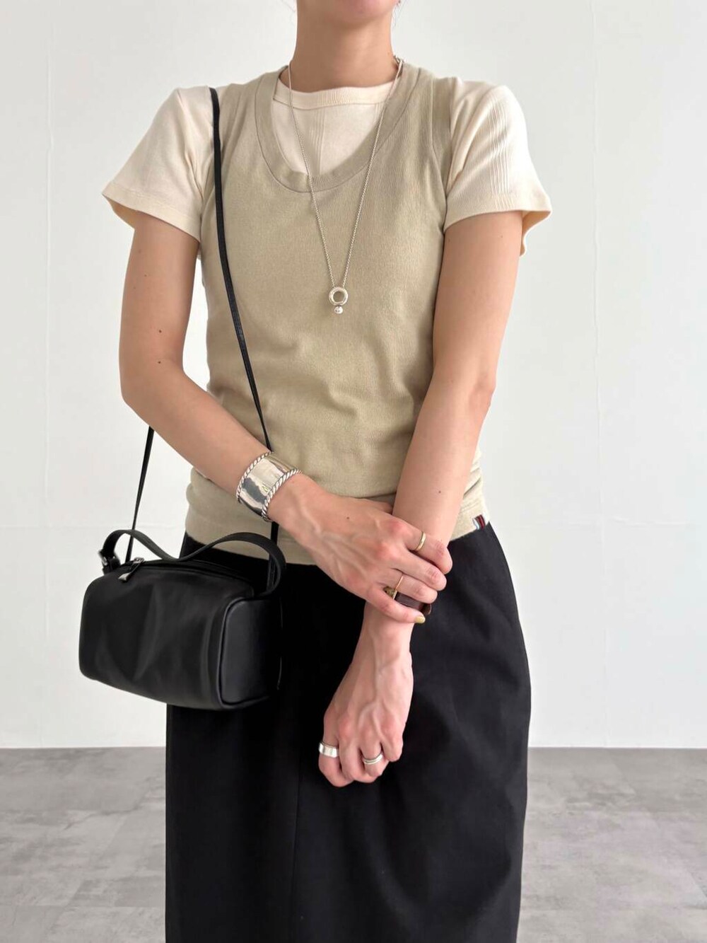 ブラック系のスカート、ブラック系のショルダーバッグ、ブラック系のサンダルを着用したレディースの夏コーディネートの6枚目の写真