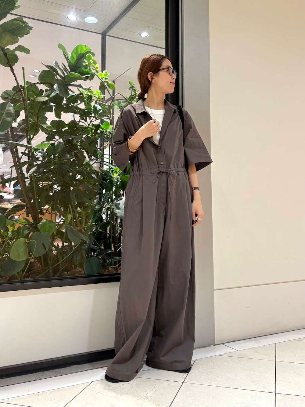 ブラック系のサンダル、ブラウン系のサロペット/オーバーオール、ホワイト系のタンクトップを着用したレディースの夏コーディネートの4枚目の写真