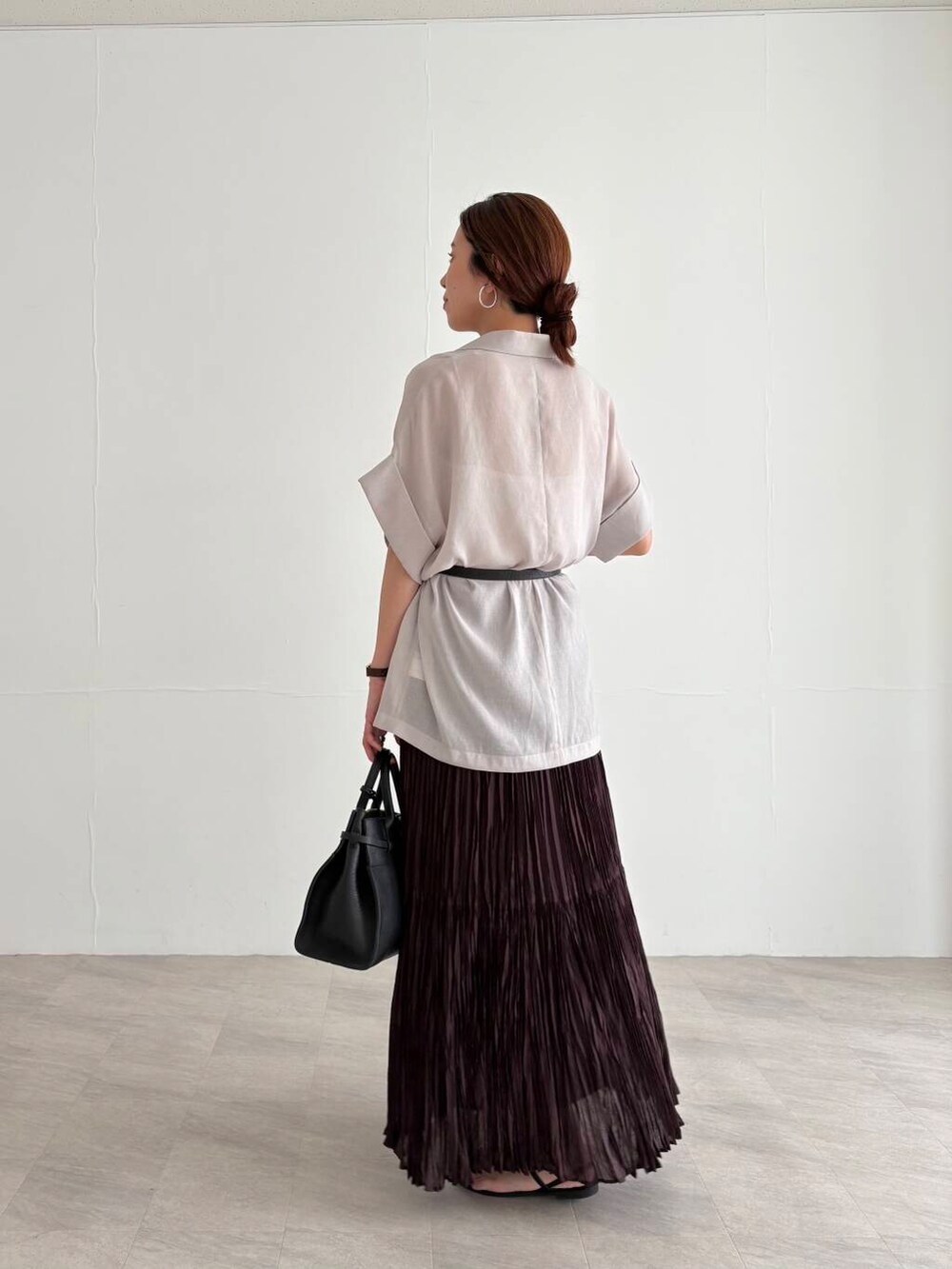 ホワイト系のキャミソール、ブラウン系のスカート、ブラック系のサンダルを着用したレディースの夏コーディネートの3枚目の写真