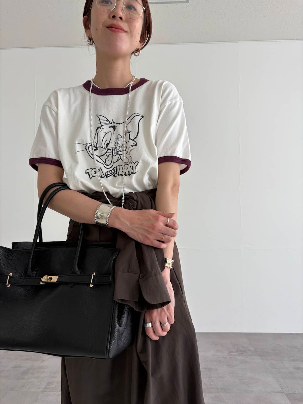 ブラウン系のサロペット/オーバーオール、ホワイト系のTシャツ/カットソー、ブラック系のサンダルを着用したレディースの春コーディネートの7枚目の写真